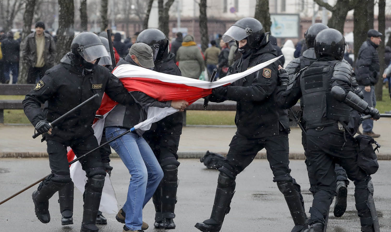 Belarus police detain a protester with an opposition flag during an opposition rally in Minsk, Belarus, Saturday, March 25, 2017. A cordon of club-wielding police blocked the demonstrators' movement along Minsk's main avenue near the Academy of Science. Hulking police detention trucks were deployed in the city center. п»їп»ї(AP Photo/Sergei Grits)
